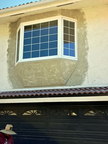 Bay window with fresh stucco return after a same-day repair.
