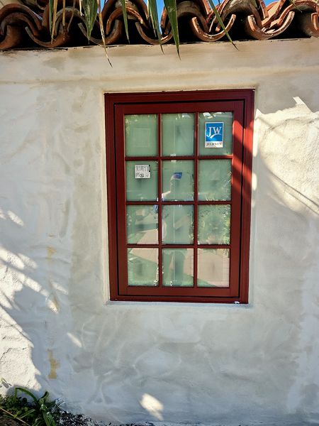 Spanish window on a 1920s Golden Hill home with restored white stucco around it.